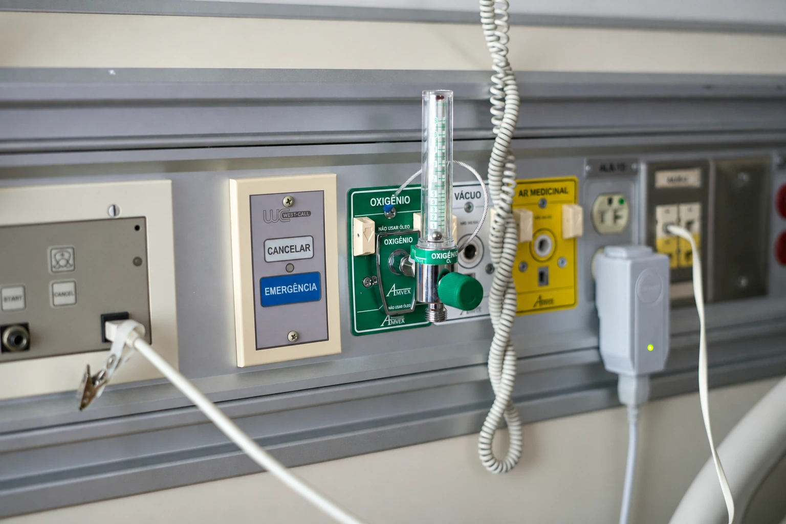 Painel de gases medicinais com identificação adaptada em português: oxigênio, ar medicinal e vácuo; fotografia de referência